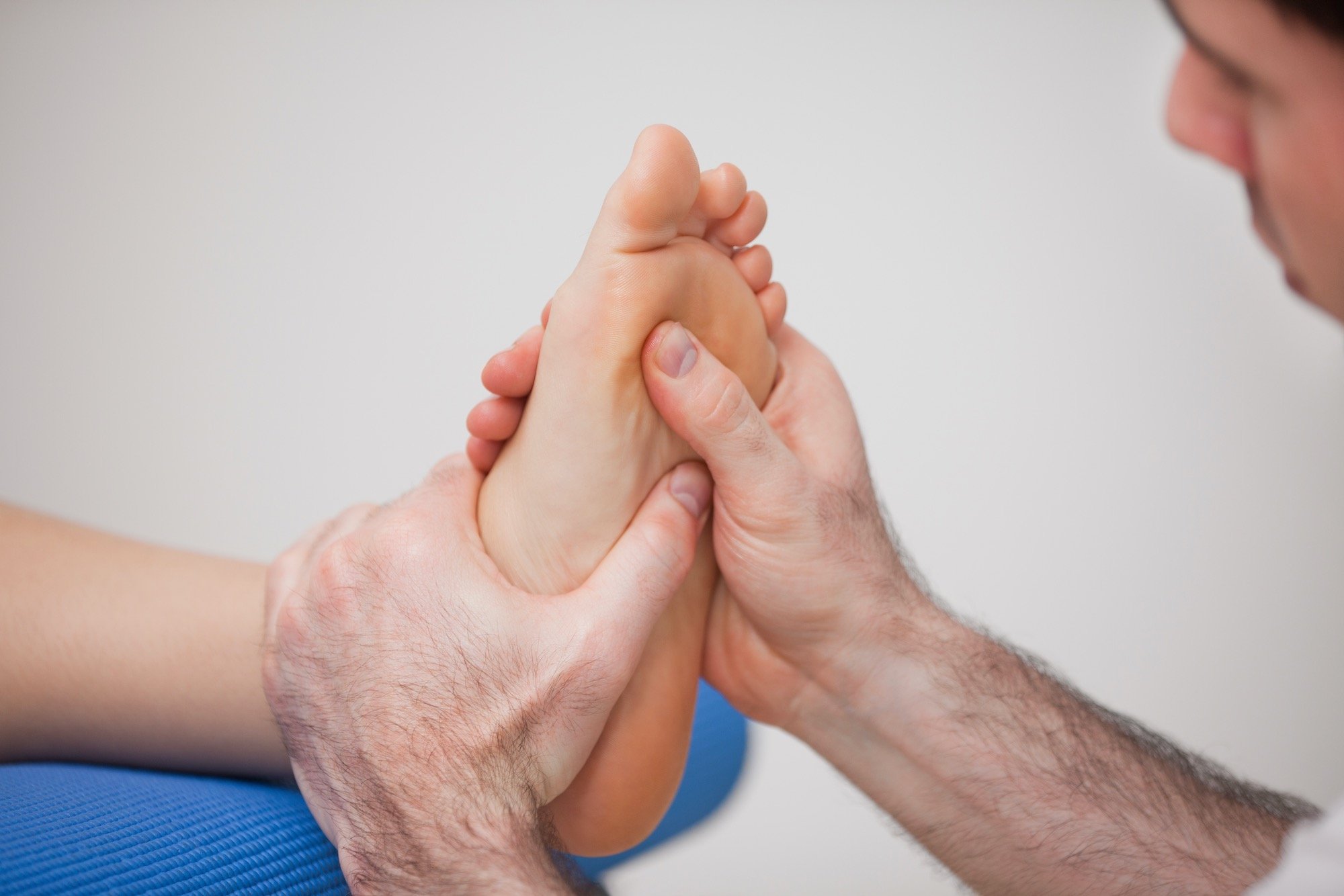 regenerative-stem-cell-injection-therapy-man-evaluating-feet-massaging_afd Man Sitting in Evaluation Before Laser Foot Therapy Injection