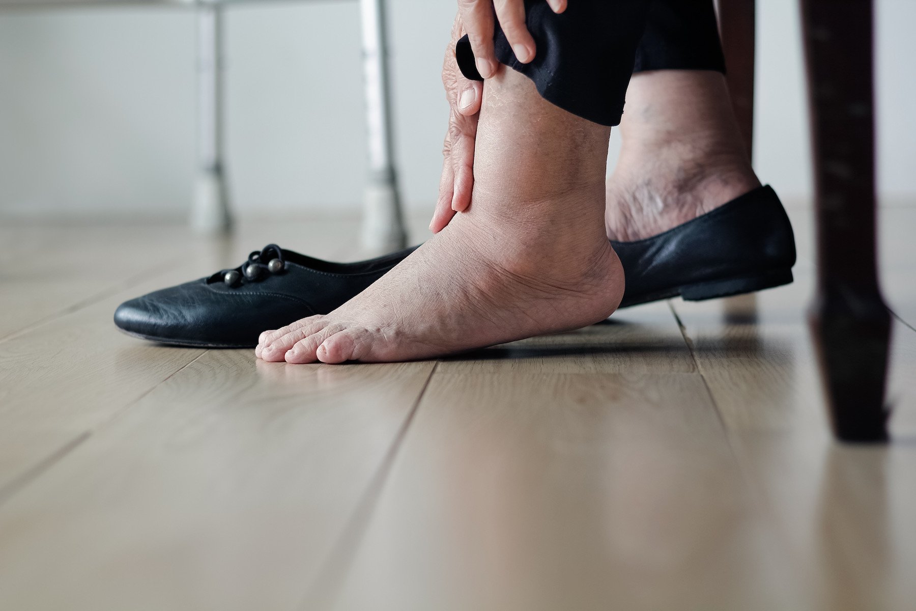 elderly women holding swollen foot after a long day
